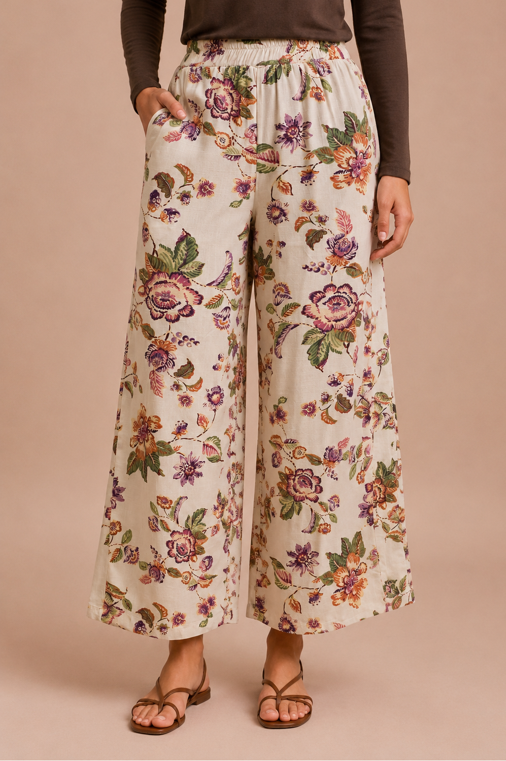 Woman wearing a brown long-sleeve top and floral wide-leg pants on a beige background
