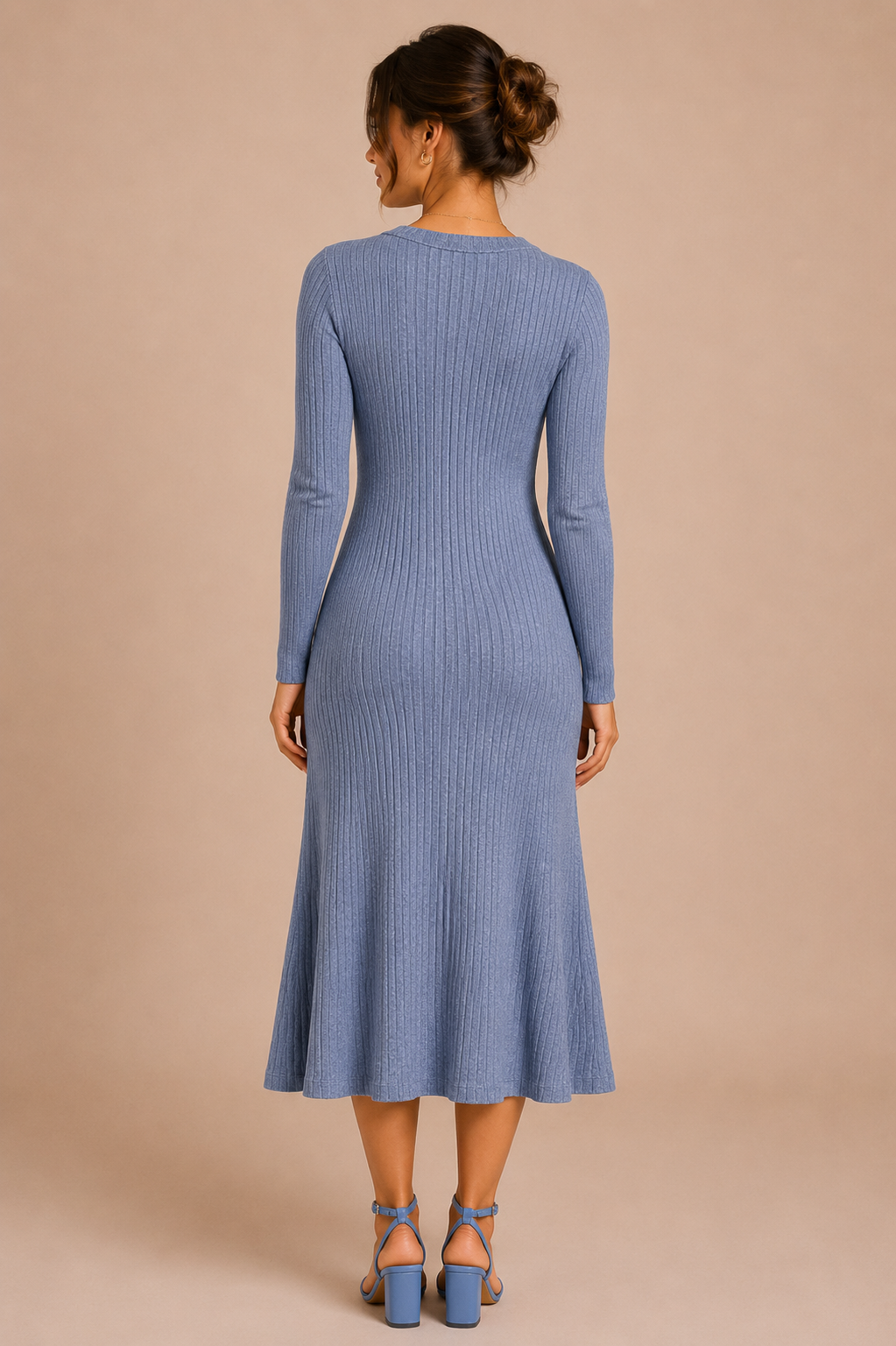 Woman wearing a blue ribbed dress against a beige background