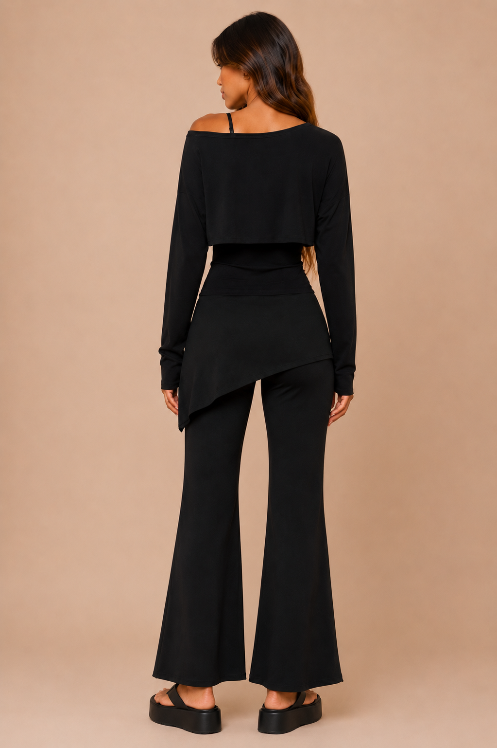Woman wearing a black outfit with a beige background