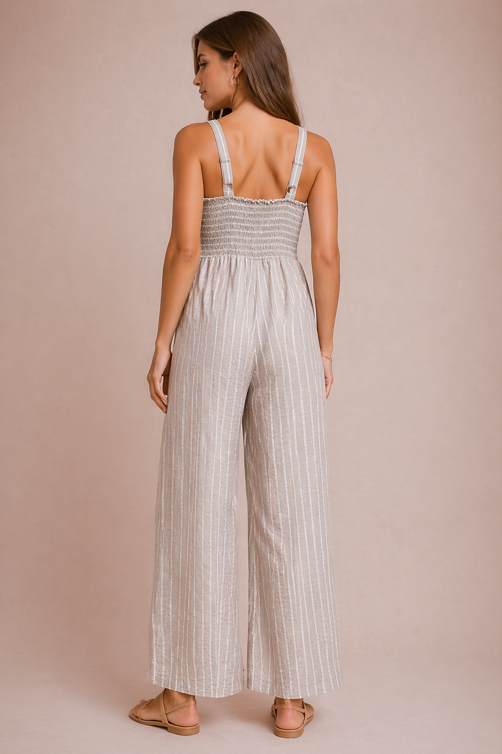 Woman wearing a striped jumpsuit on a beige background